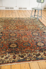 Vintage Malayer carpet's fringe, detailed border, and floral multi-medallion pattern in madder red and navy.