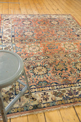 Corner of vintage Malayer rug: rust and navy floral border, softened pile, and secured fringe.