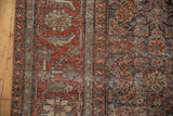 Distressed texture of Mahal carpet, revealing intricate Herati motif in wine red and visible foundation.