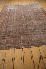 Distressed Mahal carpet close-up, worn Herati motif, wine red and silver with visible foundation.
