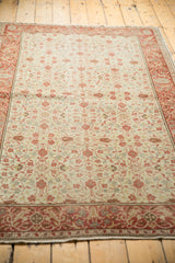 Distressed vintage Kayseri rug with intricate cochineal red floral blossoms on an ivory field.