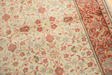 Distressed vintage Kayseri rug close-up: intricate red floral patterns, ivory field, wear showing foundation.