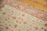 Curvilinear floral pattern of the distressed Kayseri rug in antique ivory and muted red.