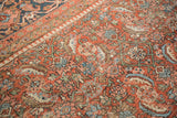 Vintage Heriz carpet: Oversized Herati motif in brick red, dusty navy, and visible wear.