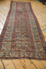 Antique Kurdish runner with geometric vinery, starburst flowers, and faded colors; showing mostly even wear.