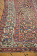 Antique Kurdish runner detail: geometric vinery border, faded raspberry and teal, with foundation wear.