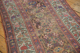 Kurdish runner close-up of palmette pattern with faded raspberry and teal, showing exposed foundation.