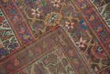 Antique Kurdish runner with faded red geometric vinery, starburst motifs, and visible foundation wear.
