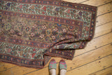 Antique Kurdish runner with faded raspberry geometric patterns and mostly even foundation wear.