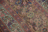 Detail of antique Kurdish runner showing worn palmette medallions, geometric vinery, and exposed foundation.