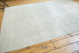 Soft ivory, pale blue, and platinum floral motif on a distressed Sivas rug edge.