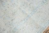 Distressed vintage Sivas carpet with subtle sprawling floral design in ivory and pale blue.