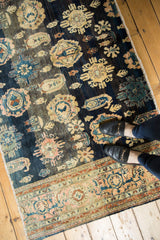 Antique Farahan Sarouk runner section displaying floral palmettes, botehs, navy, and dusty blush.