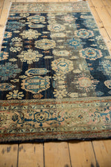 Antique Persian Farahan Sarouk rug's lower border detail, with blush, ivory floral patterns and navy field motifs.