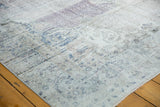 Worn pile of a distressed vintage Oushak rug, with faded blue, mauve, and white patterns.