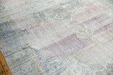 Distressed vintage Oushak carpet's faded mauve, purple, and teal surface with visible foundation wear.