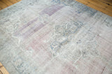 Distressed vintage Oushak rug pile with visible knot heads, faded mauve, purple, teal patterns.