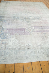 Close-up of distressed Oushak pile with faded white, mauve, and blue tones, showing wear to foundation.