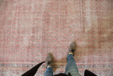 Distressed Sivas carpet field with blush rose, ivory tones, and textured boteh motifs.