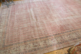 Blush rose distressed Sivas carpet, showing even wear and patterned blue border.