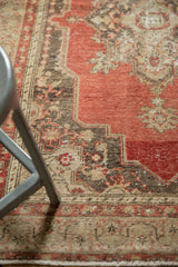 Distressed Oushak rug's detailed corner spandrels in muted red, ivory, and oxidized silver.