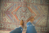 Distressed vintage Oushak rug with mostly even wear and faded terracotta, slate blue patterns.