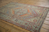 Vintage distressed Oushak rug's faded terracotta, slate blue, and beige geometric patterns.