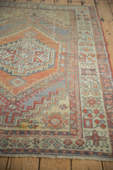 Worn pile and geometric patterns in terracotta, slate blue, and beige on a vintage Oushak rug.
