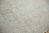 Distressed Oushak rug, showing low pile texture, ivory, pale gray colors, and visible repair.