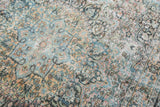 Distressed Khorassan rug texture, showing intricate blush, teal, and pale gold floral patterns.