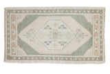 Vintage Distressed Oushak rug, ivory medallion, serrated celadon green field, soft worn texture.