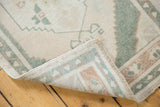 Vintage Distressed Oushak rug displaying intact side cord selvage and ivory, celadon pile texture.