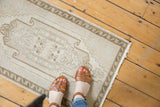Vintage Oushak rug with pale ivory curvilinear medallion and soft, low pile texture.