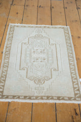 Distressed Oushak rug mat with bottom fringe and faded ivory, pale bronze patterns.