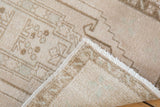 Vintage distressed Oushak rug's ivory pile with intact selvage, fringe, and woven foundation.