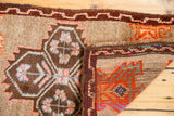 Vintage Oushak rug showing brown quatrefoil pattern on pile and tangerine hand knotted foundation.