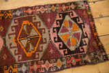 Vintage Oushak runner edge showcasing playful geometric patterns in aubergine, blush, and tangerine.