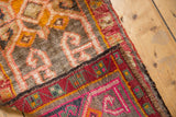 Vintage Oushak rug's thick pile, secured edge, and colorful geometric hand-knotted backing.