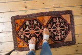 Vintage Oushak rug mat with tangerine, chocolate, and red geometric double medallion.