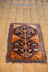 Corner of a Vintage Oushak rug showing tangerine orange, chocolate brown, and vine motif border.