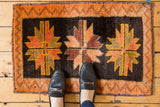 Hand-knotted vintage Oushak rug showing central floral medallion in tangerine, gold, and wine tones.