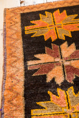 Orange zig-zag border, secured side, and dark brown field with floral petals.