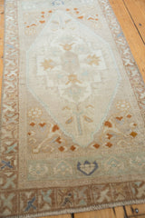 Distressed lower border of the vintage Oushak rug with pale blue, sand, and terracotta motifs.