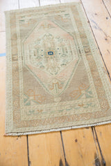 Distressed Oushak rug showcasing intricate serrated field, scrolling florals, and soft pastel abrashes.