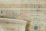 Distressed Turkish Oushak rug close-up: muted tones, textured pile, and hand-knotted reverse.