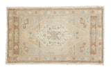 Distressed Oushak rug mat, central medallion with floral sections in ivory, sand, and mint.