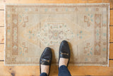 Distressed Oushak rug with worn central medallion and subtle ivory, bronze, mint hues.