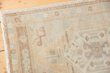 Corner view of vintage distressed Oushak rug, showing original selvage and soft muted patterns.