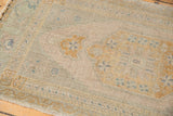 Distressed Oushak rug's muted gold and platinum floral motifs on a time-softened ground.