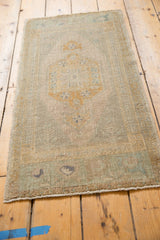 Turkish Oushak rug end with even pile wear, secured selvage, and gold, oxidized silver hues.